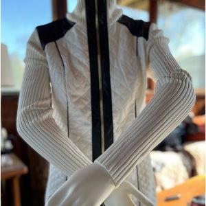 A stunning woman’s black & white zip up sweater with faux leather